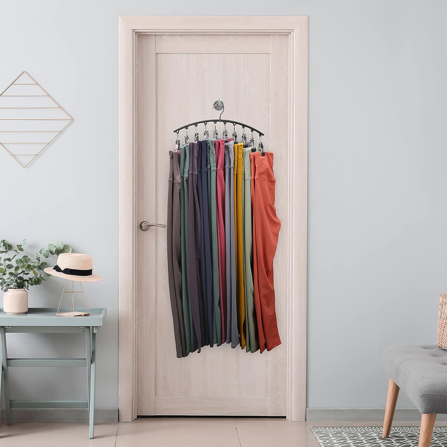 Colorful pants hanging on a door with a minimal room interior.