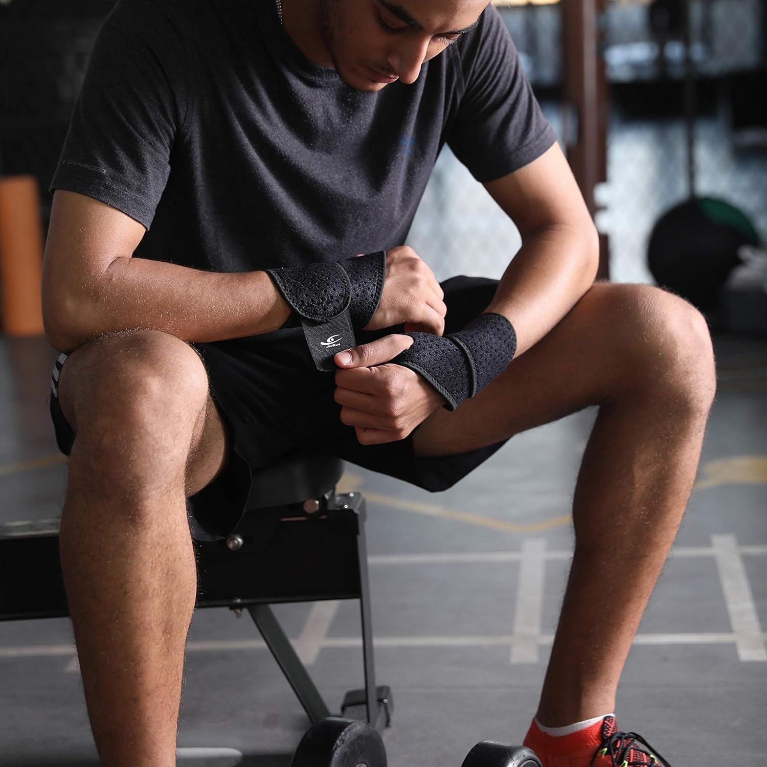 Person preparing for a workout by wrapping their wrist in a gym setting